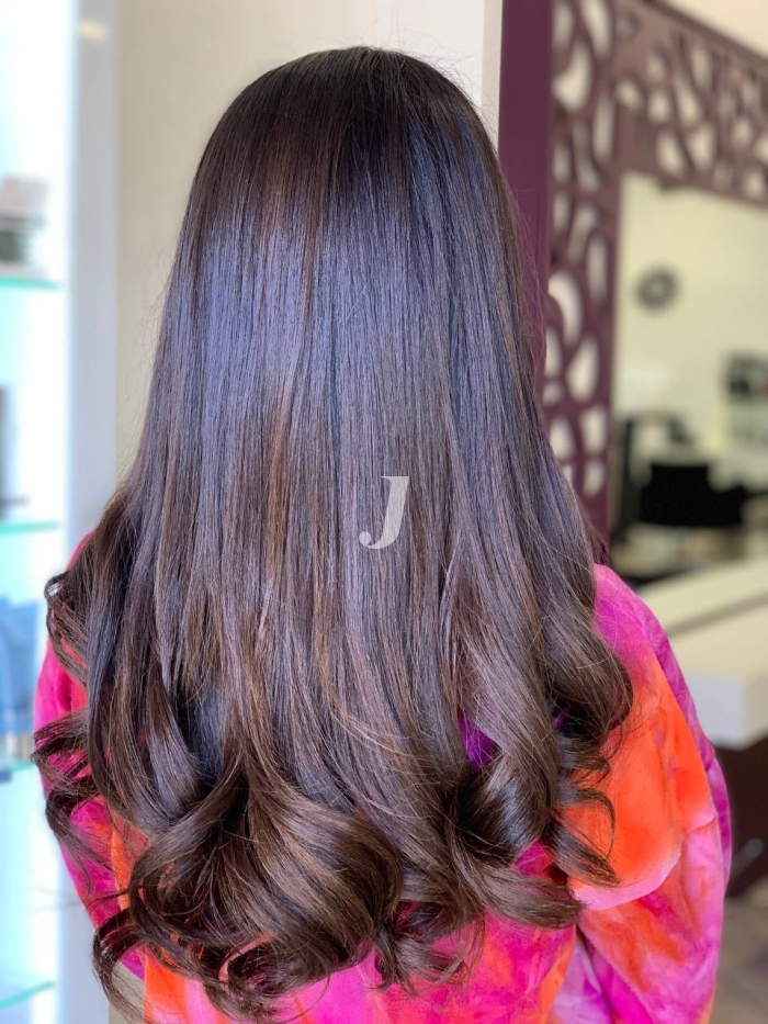 Foto di donna con capelli lunghi castano scuro mogano o violino