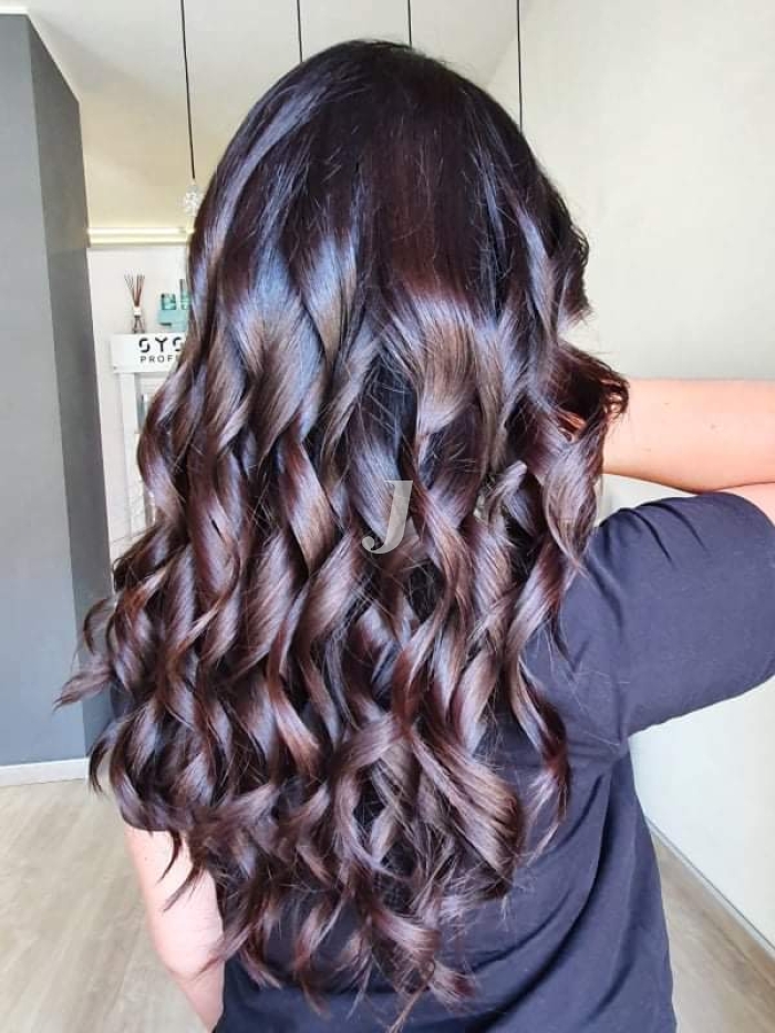 Foto di donna con capelli lunghi castano scuro mogano o violino